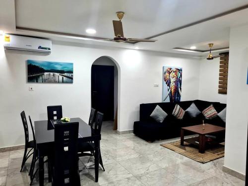 a living room with a black couch and a table at Spacious Quiet & Cozy- Close to Highway-Parking in Apenkwa