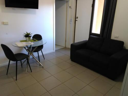 a living room with a black couch and a table at Caravilla Motor Inn in Taree