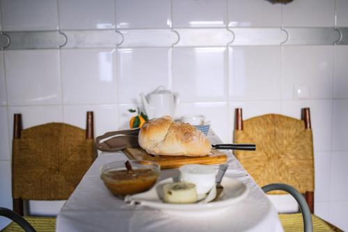 a table with a loaf of bread and a plate of food at Os 5 Sentidos in Mourão