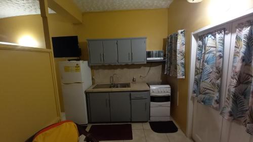 a small kitchen with a sink and a refrigerator at Wallace Holiday Apartments in Scarborough