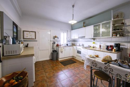 a kitchen with white cabinets and a table in it at Os 5 Sentidos in Mourão