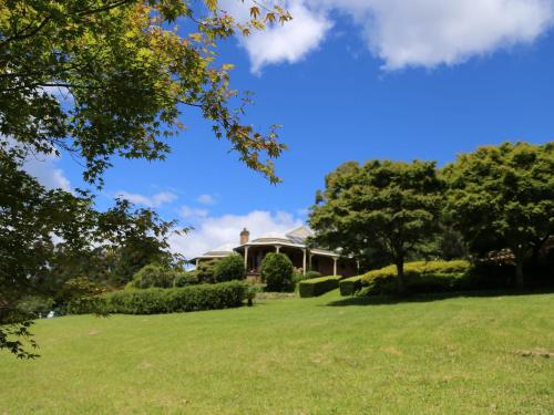 a house on a green lawn with a tree at Tiverton in Kurrajong