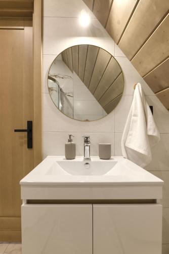a bathroom with a white sink and a mirror at Hill House Apartamenty w cichej i spokojnej okolicy blisko Term Bania gorąca balia,bilard in Białka Tatrzańska