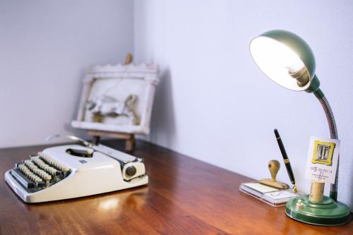 a desk with a lamp and an old fashioned typewriter at Os 5 Sentidos in Mourão