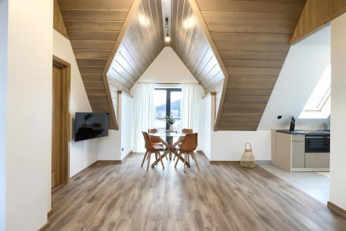 a kitchen and dining room with a table and chairs at Hill House Apartamenty in Białka Tatrzanska