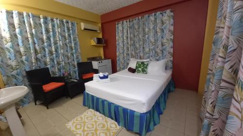 a small room with a bed and a chair at Wallace Holiday Apartments in Scarborough