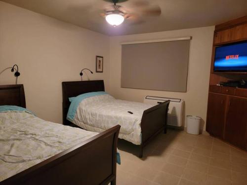 a bedroom with two beds and a flat screen tv at Private Beachfront House in Cabo Rojo