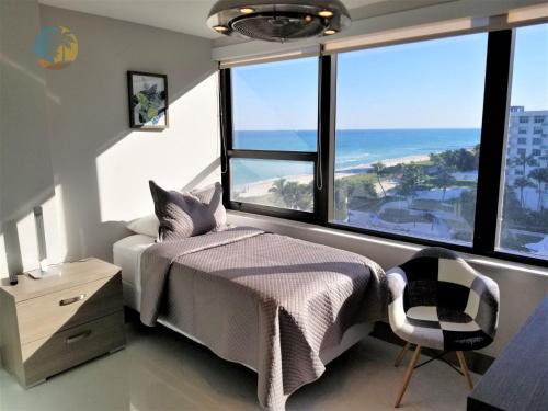 Luxury Beach Resort - HORA RENTALS في ميامي بيتش: غرفة نوم مع سرير وإطلالة على المحيط