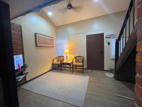 a living room with a table and chairs and a door at Grand Lodge Langkawi in Pantai Cenang