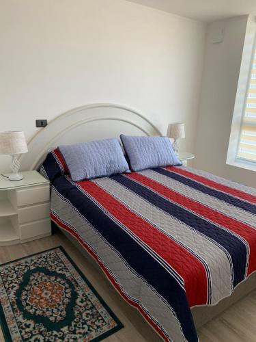 1 dormitorio con 1 cama con manta roja blanca y azul en Caupolican 243 en Valdivia