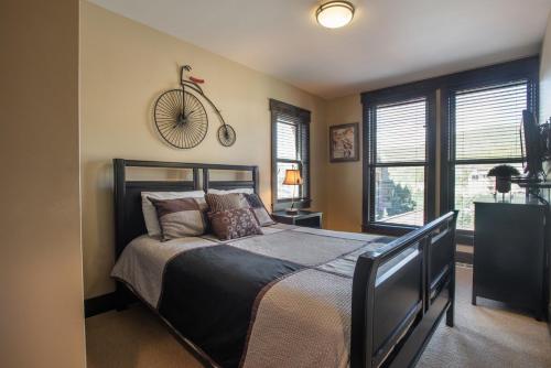 a bedroom with a bed with a bicycle on the wall at Spacious Village View Townhouse with Fireplace at Parry Peak Lofts townhouse in Winter Park
