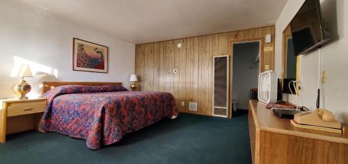 a hotel room with a bed and a television at Budget Inn Motel Gallup in Gallup