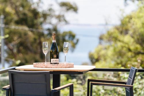 a bottle of champagne and two glasses on a table at Beach Walk on Alfred in Bridport