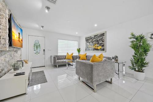 a living room with a gray couch and yellow pillows at **MODERN 3BEDROOM W/ STUNNING BACKYARD AREA** in Fort Lauderdale