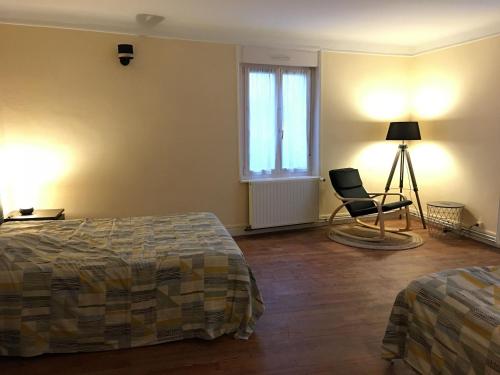 - une chambre avec deux lits, une chaise et une lampe dans l'établissement Gîte Velle-sur-Moselle, 3 pièces, 5 personnes - FR-1-584-178, à Velle-sur-Moselle