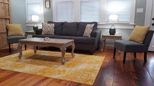 a living room with a couch and a table and chairs at The Lafayette House in Mobile