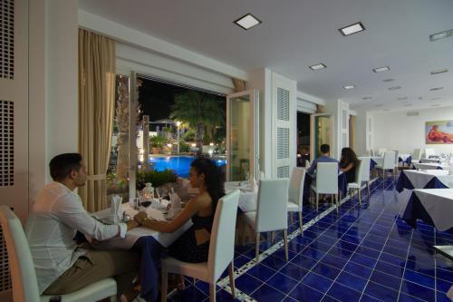 a man and woman sitting at a table in a restaurant at Grifo Hotel Charme & SPA in Ischia