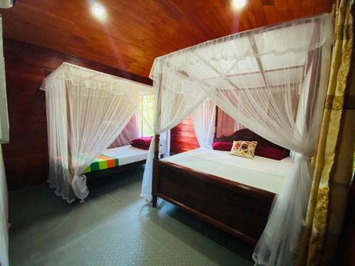 a bedroom with two bunk beds with mosquito nets at Little Pumpkin Cabanas in Tangalle