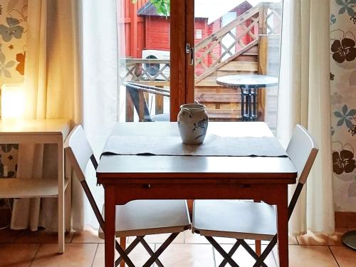 a table with white chairs and a vase on it at 3 person holiday home in TORSLANDA-By Traum in Hällsvik
