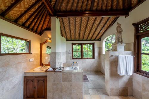 uma grande casa de banho com banheira e lavatório em Alam Jiwa Ubud em Ubud