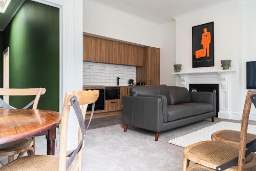 ein Wohnzimmer mit einem Sofa und einem Tisch in der Unterkunft Premium Living on Stuart St in Dunedin