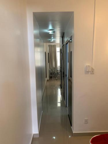 a hallway with a hallway leading to a room with white walls at Adolfo Paiva Apartment in Rio de Janeiro