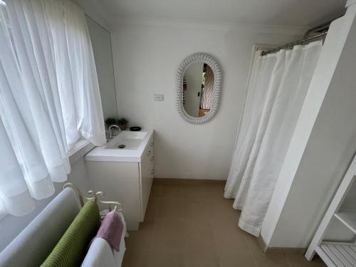 a bathroom with a washing machine and a mirror at The Little House on The Hill in Badger Creek