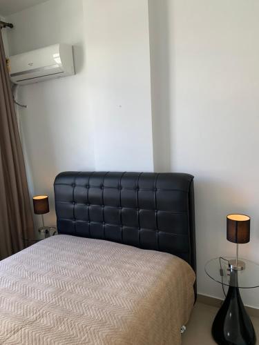 a bed with a black leather headboard in a room at Adolfo Paiva Apartment in Rio de Janeiro