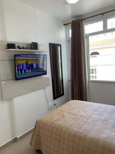 a bedroom with a flat screen tv on a wall at Adolfo Paiva Apartment in Rio de Janeiro