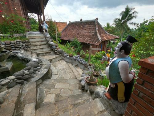 a statue of a man standing in front of a house at Wisma Pancoeran in Grigak