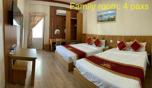 ein Hotelzimmer mit 2 Betten und einem Tisch in der Unterkunft King Hotel in Quy Nhon