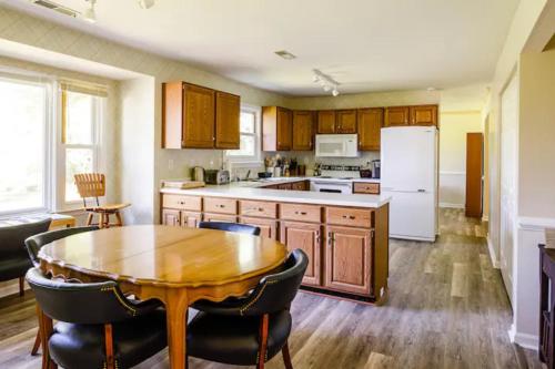 a kitchen with a wooden table and a white refrigerator at La Maison des Ours in Earlysville