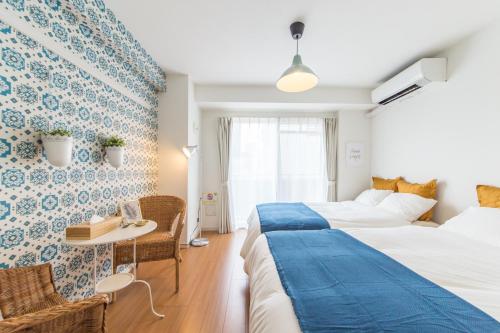a hotel room with two beds and a table and chairs at SHINJUKU Residence BLDG in Tokyo