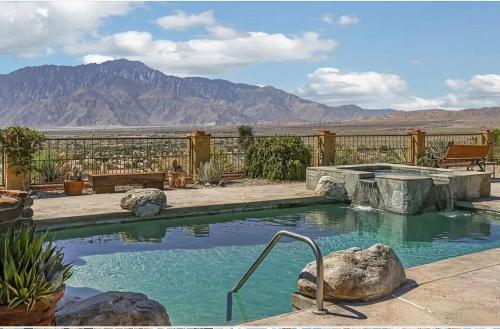 a swimming pool in a yard with mountains in the background at Dessert Hot springs / Palm Springs in Desert Hot Springs
