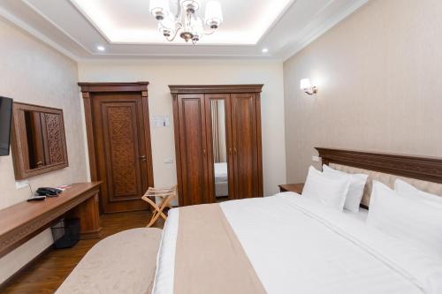 a hotel room with a bed and a chandelier at Hotel Silver Rows in Samarkand