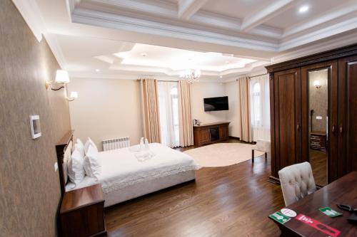1 dormitorio con cama, escritorio y mesa en Hotel Silver Rows, en Samarkand