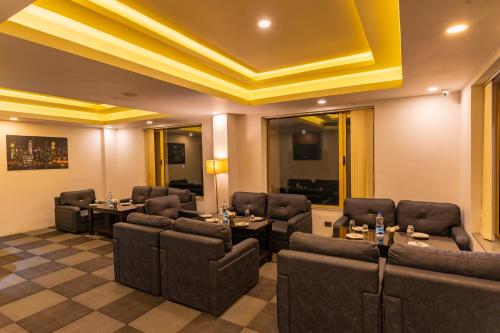 a conference room with couches and tables and a yellow ceiling at Vivanta Jamshedpur, Golmuri in Jamshedpur
