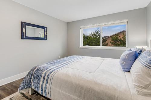 a white bedroom with a bed and a window at SurfSide in Westport