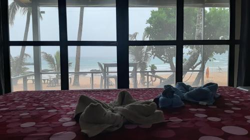 a bed with towels on it with a view of the beach at Duli Beach Resort in El Nido