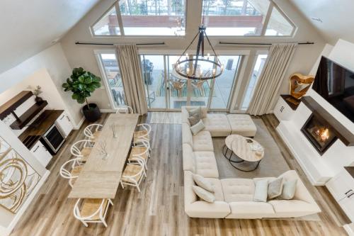 an open living room with white furniture and a table at Merganser Memories in Sunriver