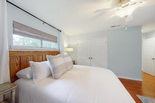 a bedroom with a white bed with white pillows at Off Course in Dauphin Island