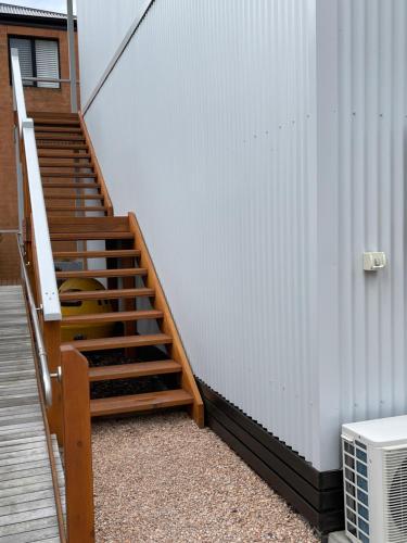 a staircase leading up to a building with a white wall at Boat Harbour Jetty B&B in Port Albert