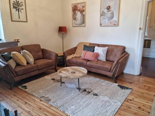 a living room with two couches and a coffee table at Historic Mintaro Post Office in Mintaro