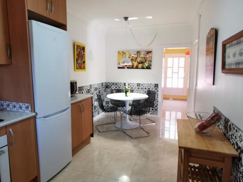 a kitchen with a white refrigerator and a table at Villa Habana in El Vendrell