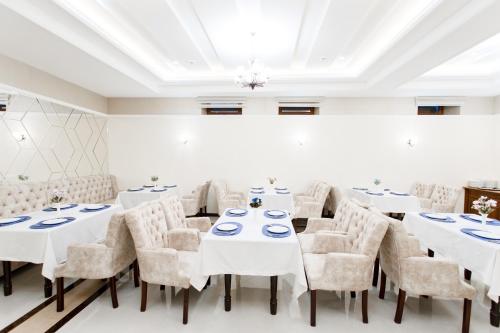 a dining room with white tables and chairs at Hotel Silver Rows in Samarkand