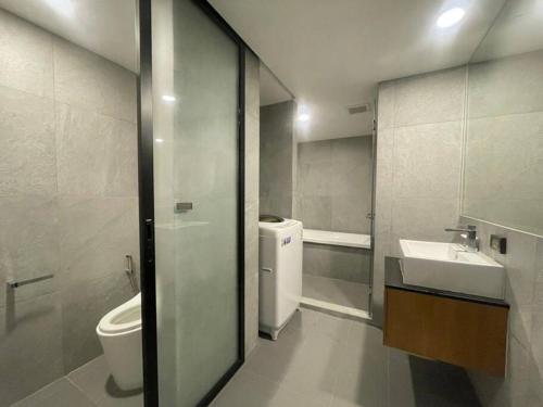 a bathroom with a sink and a toilet and a sink at 2BR Service Condo in Sriracha in Si Racha