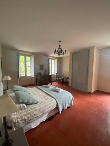 une chambre avec un grand lit et un lustre dans l'établissement CHATEAU DES SALLES, à Draguignan
