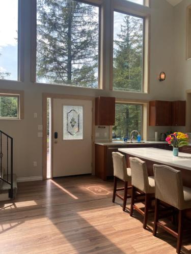 a kitchen with a table and chairs and windows at Spruce Lodge in Seward