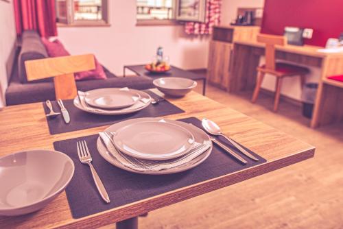 a wooden table with plates and utensils on it at DAS HÜRNER in Ansbach