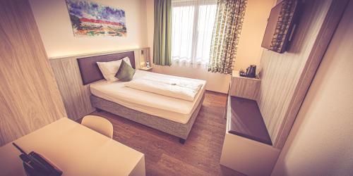 a small room with a bed and a window at DAS HÜRNER in Ansbach